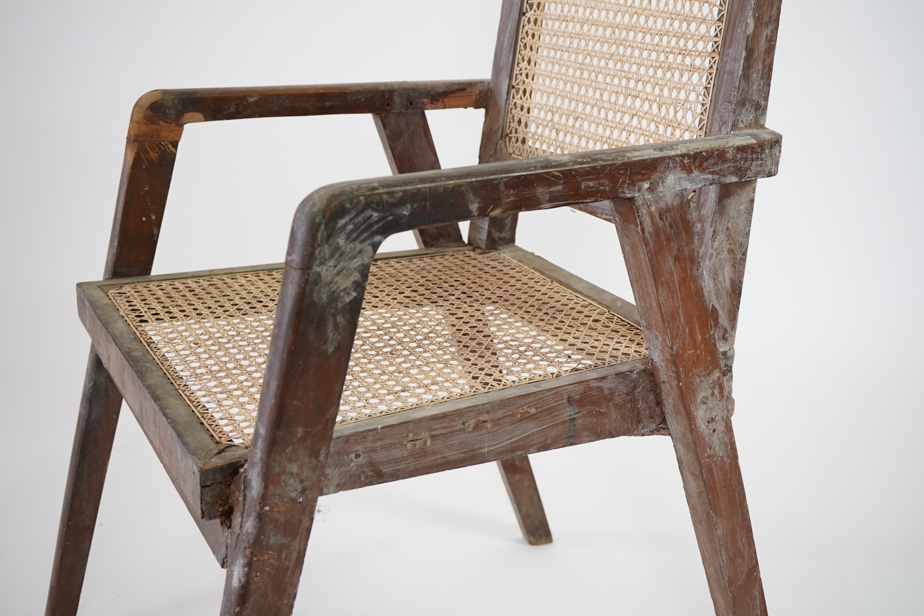 Manner of Pierre Jeanneret (Swiss, 1896-1967): A solid teak and braided canework armchair